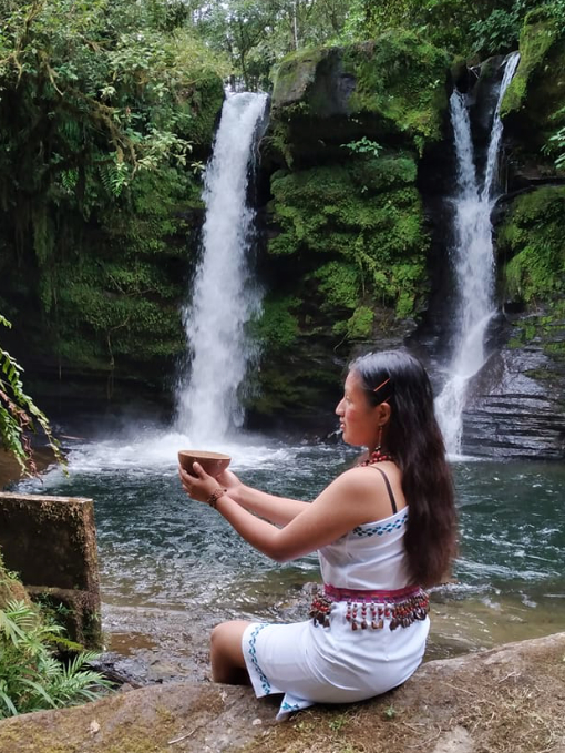 La joven kichwa Kelmy Tanguila posa ante las cascadas gemelas de Amarun Pakcha