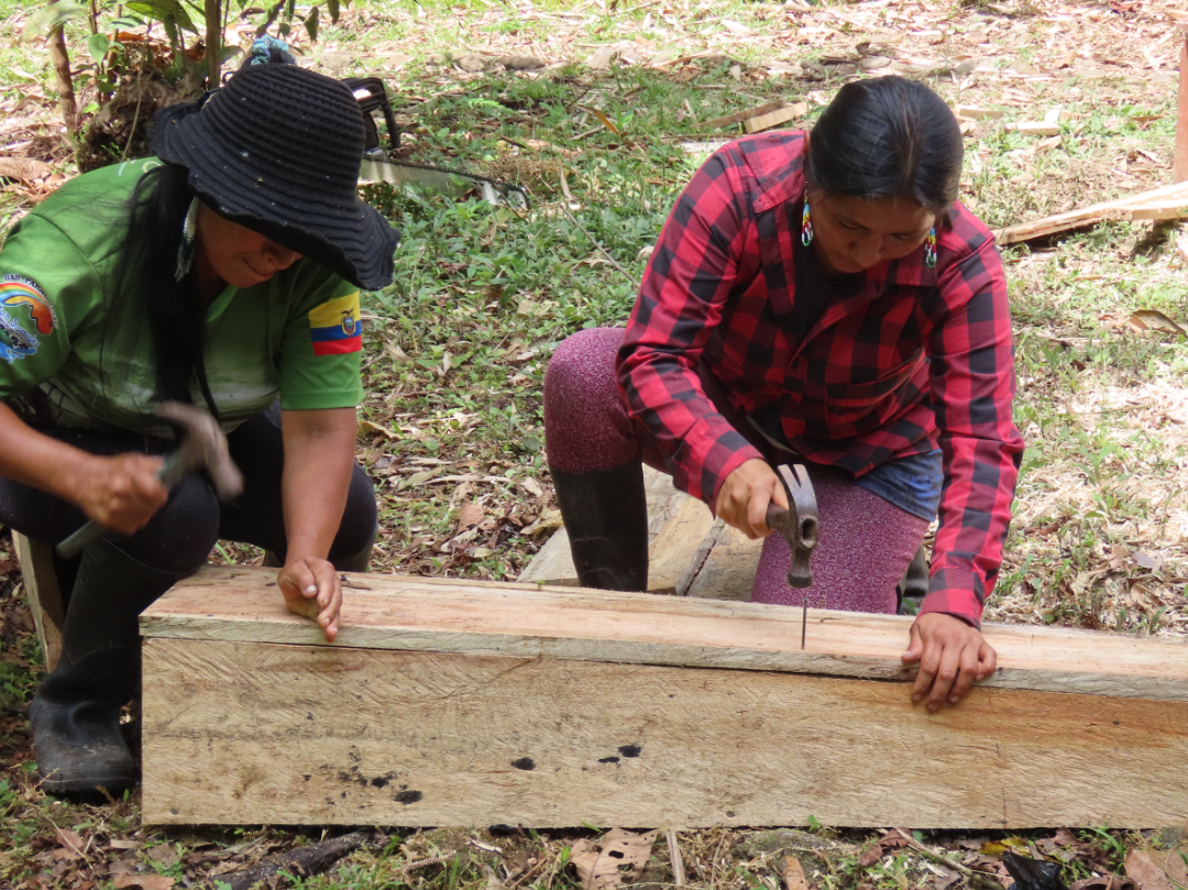 Two women hammer nails into wood